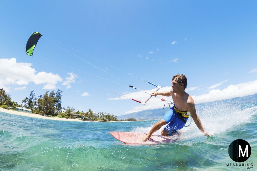 man kiteboarding on a wave