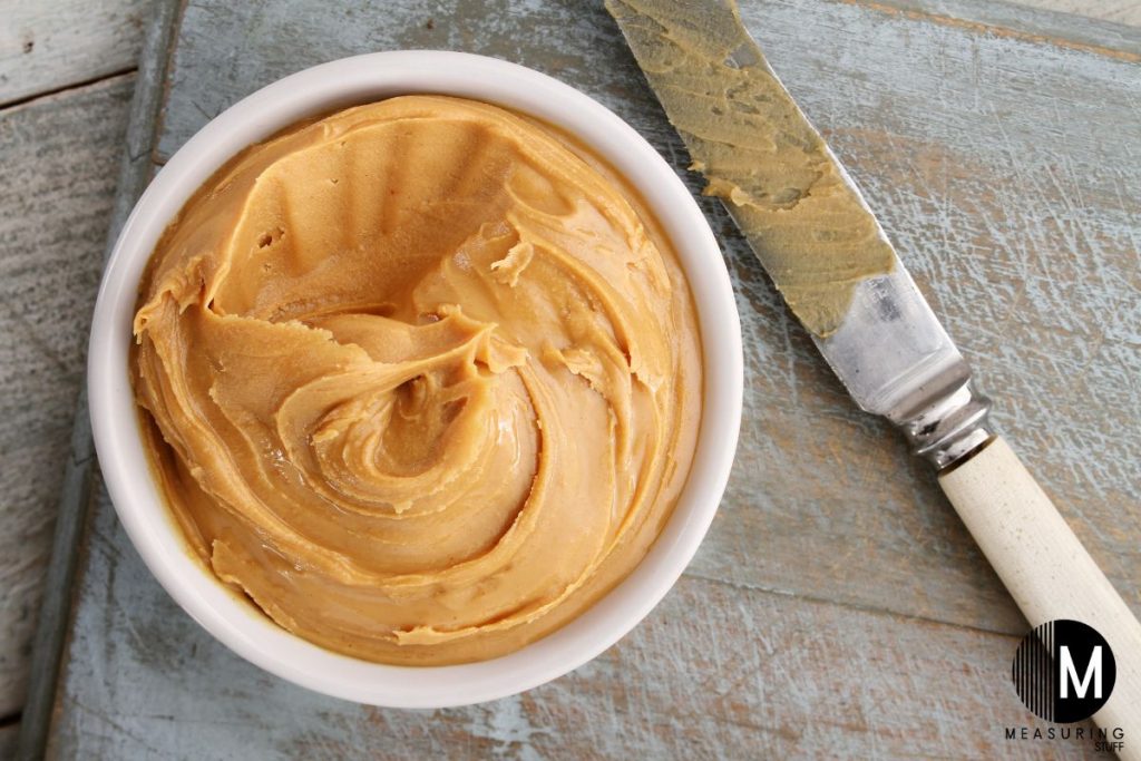 small bowl of peanut butter with knife