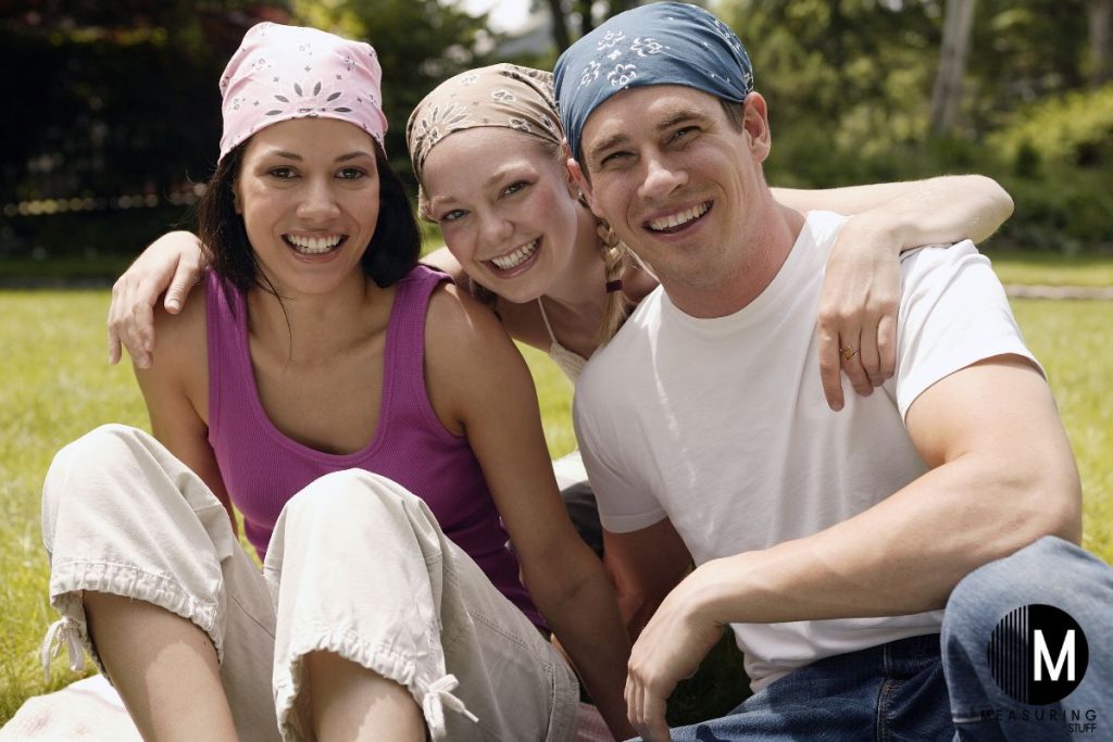 two women and a man wearing bandanas in the park