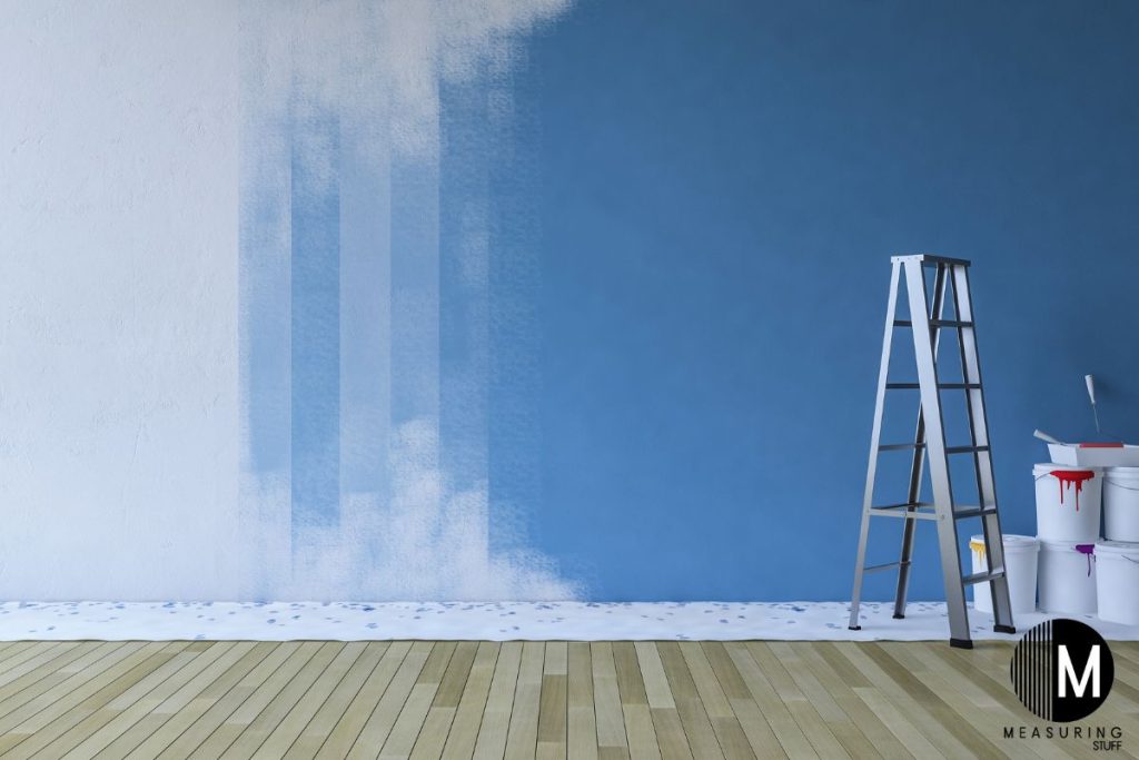 blue and white wall with a ladder and buckets on the floor