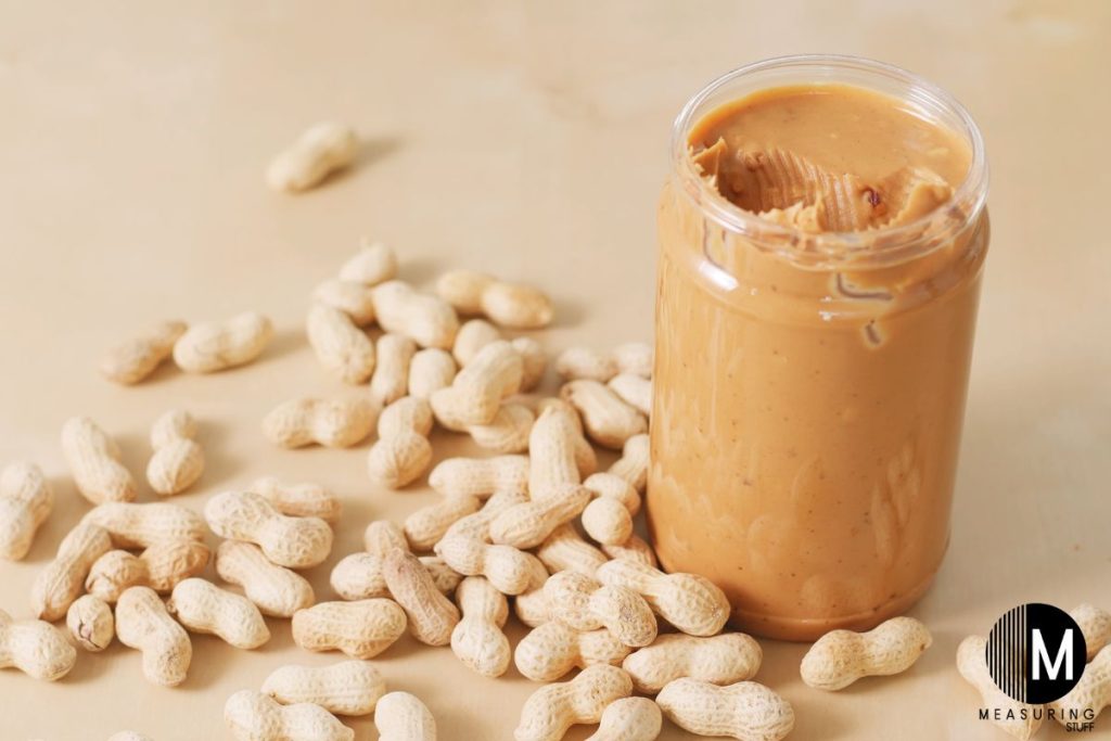 open jar of peanut butter with peanuts