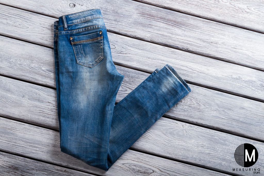 pair of jeans against a wooden wall