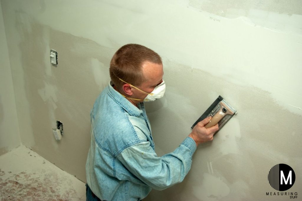 man sanding drywall