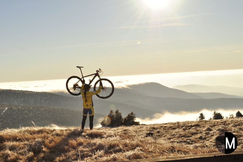 person holding a mountain bike over head