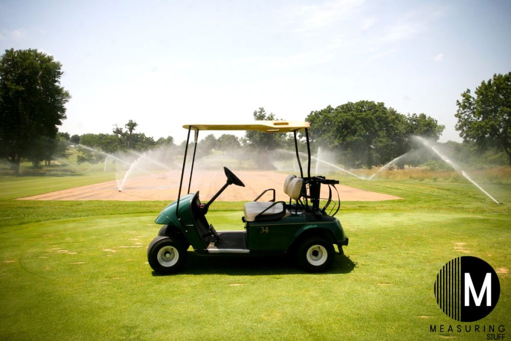 golf cart with sprinkers in background