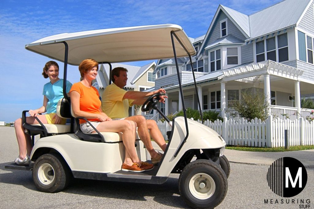 family of 3 sitting in a golf cart