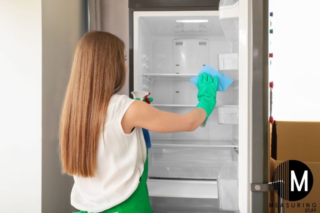 woman cleaning a refrigerator