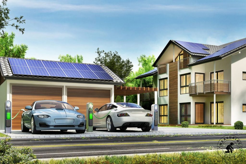 pair of electric cars charging in driveway