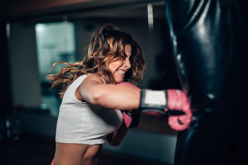 woman punching a punching bag hard