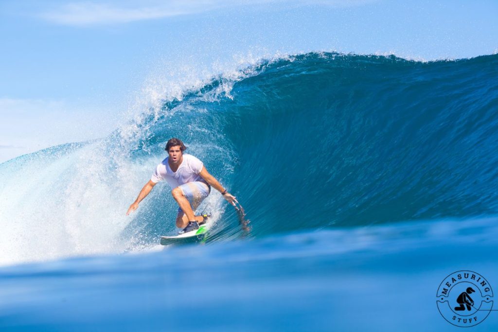 man surfing under a wave