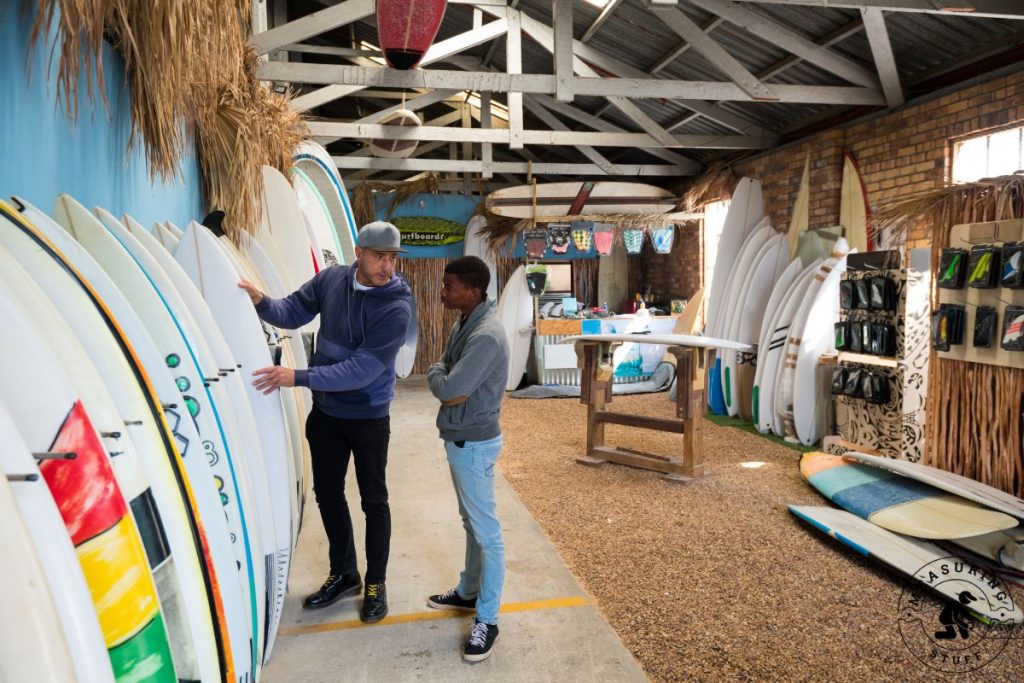 men looking at surfboards in a shop
