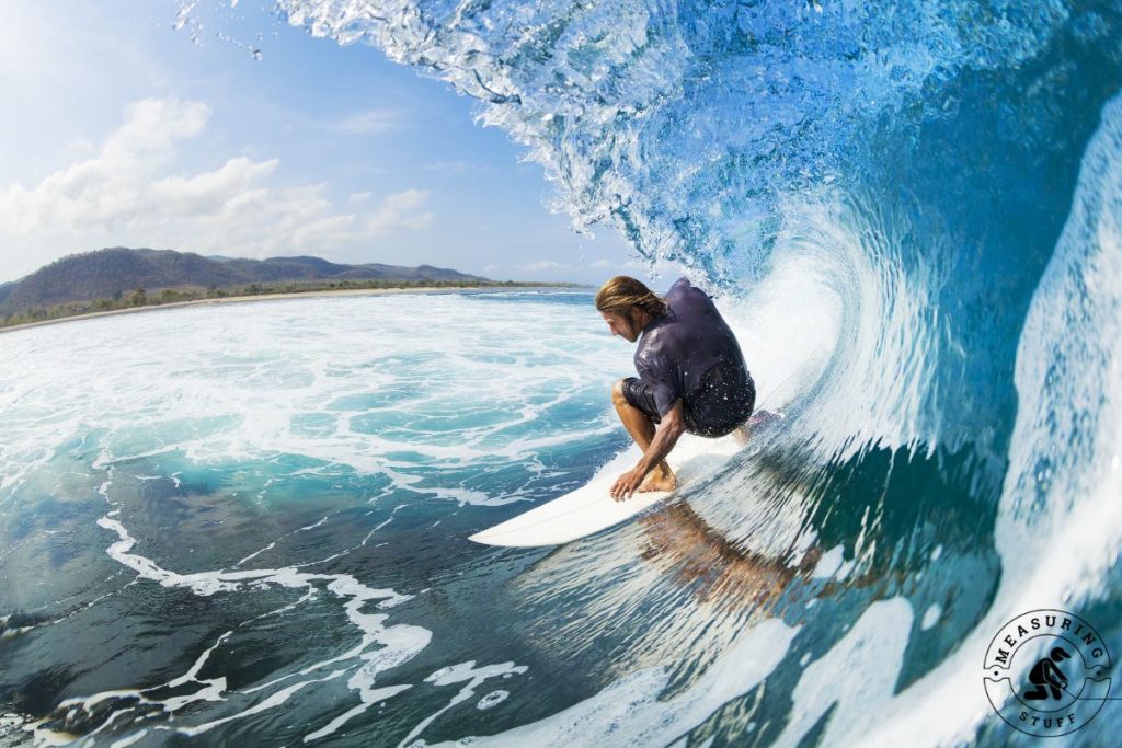 man surfing under a large wave