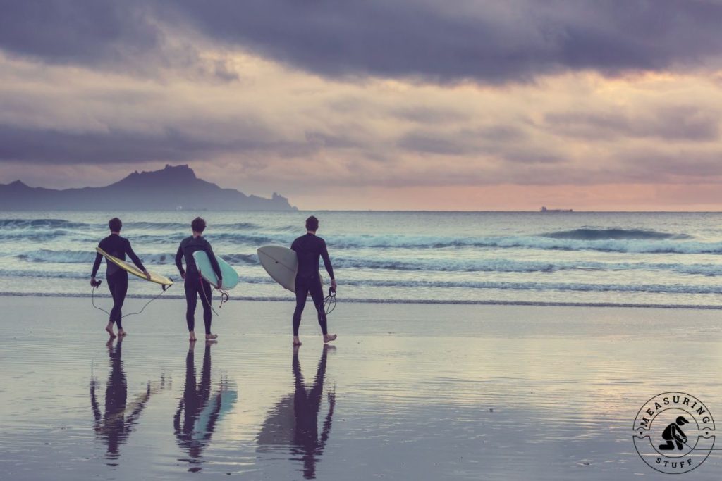 men going surfing at sunset