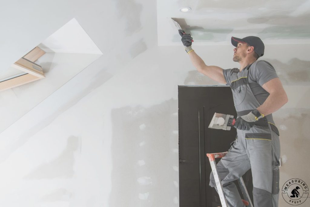man patching a wall for painting