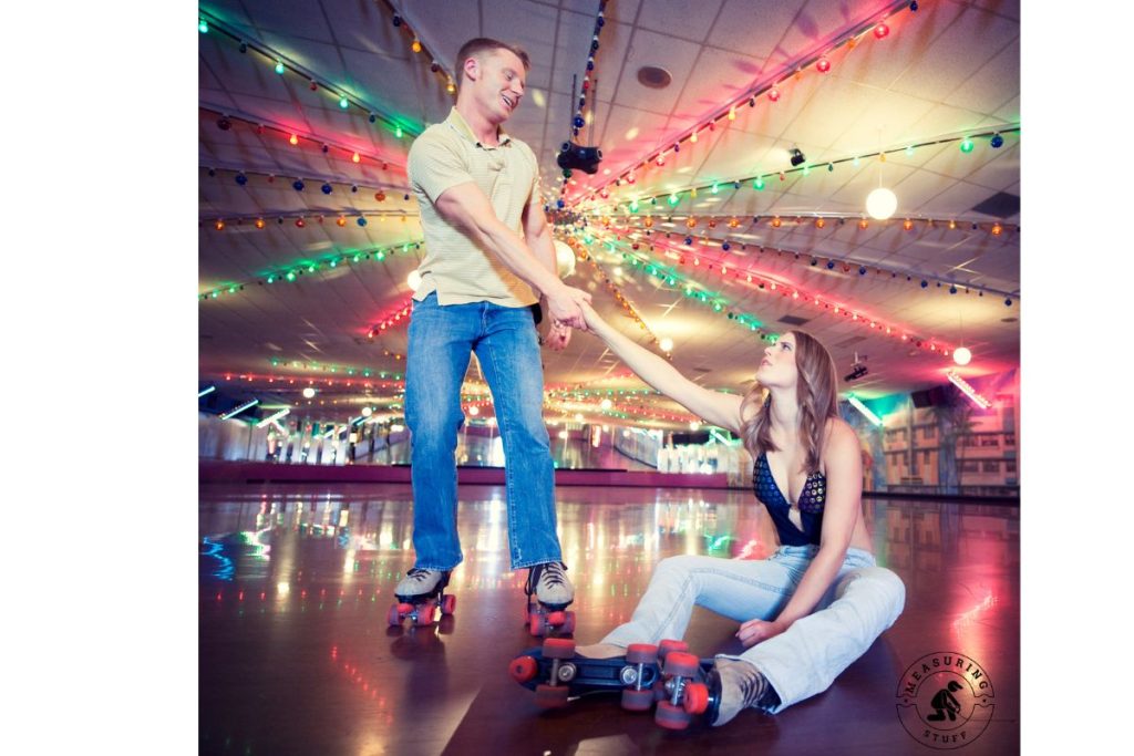 couple roller skating with woman sitting down after a fall