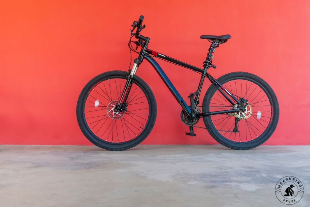 mountain bike leaning against a red wall
