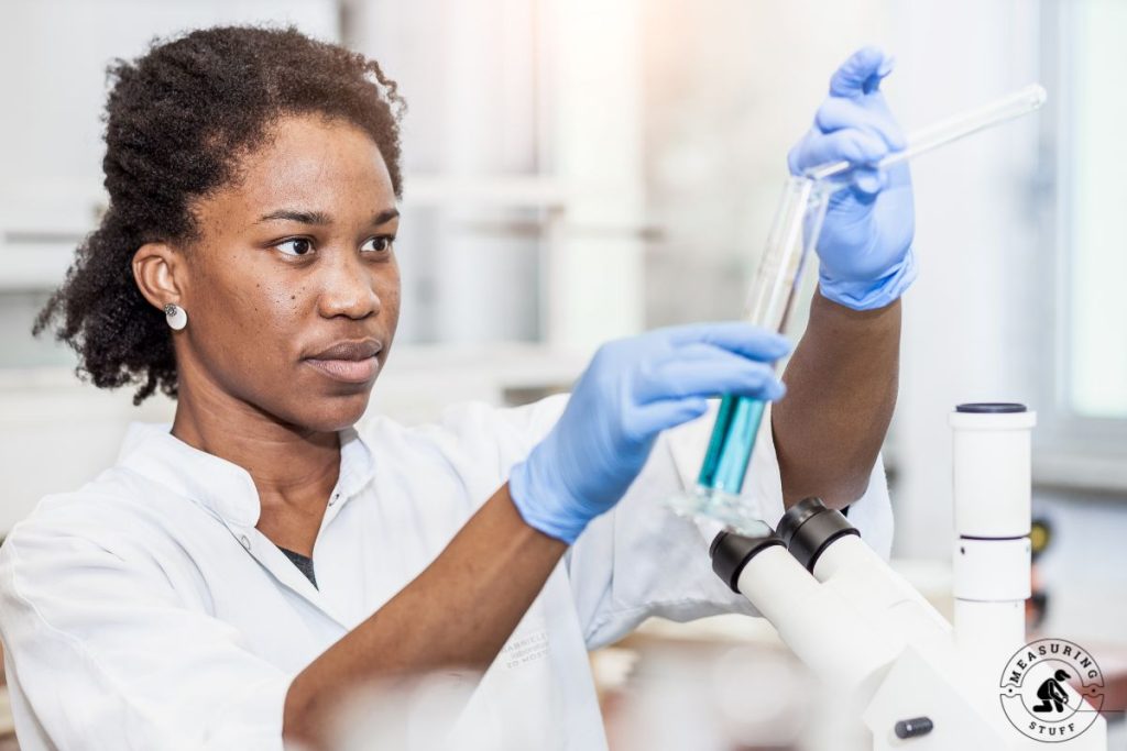 scientist pouring liquid into a measuring cylinder