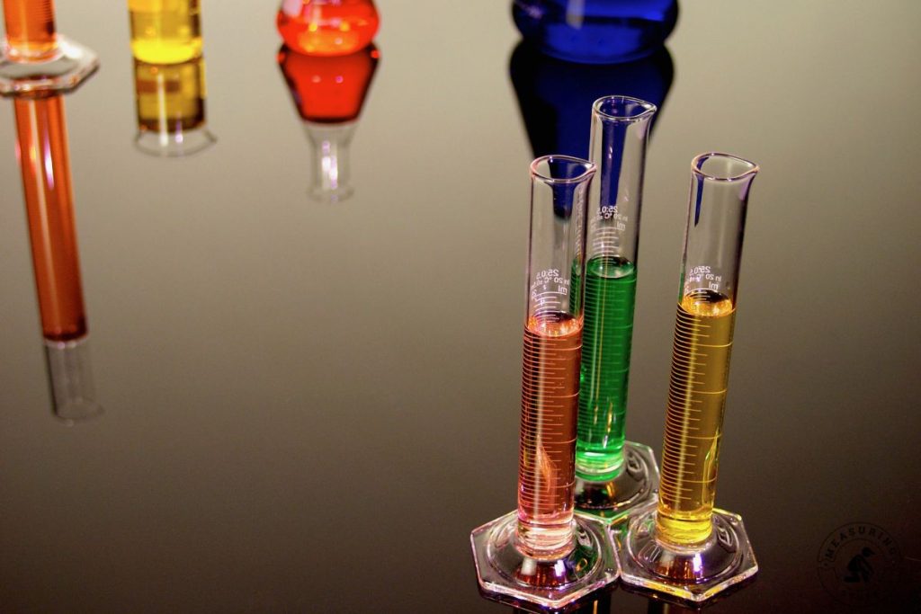 measuring cylinders filled with colored liquids