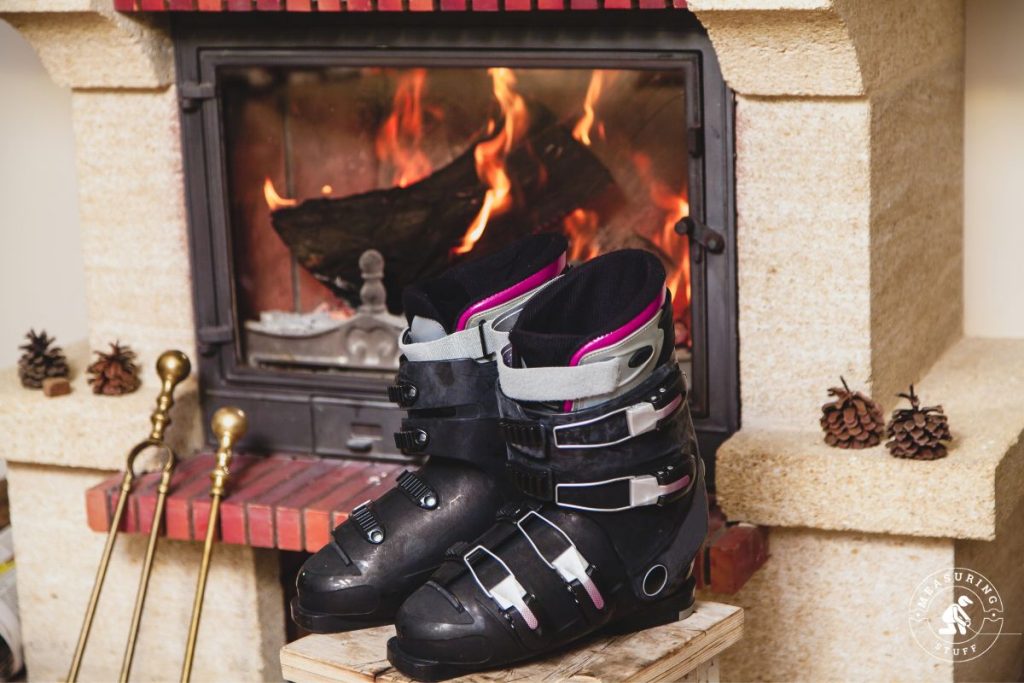 ski boots in front of a wood fireplace