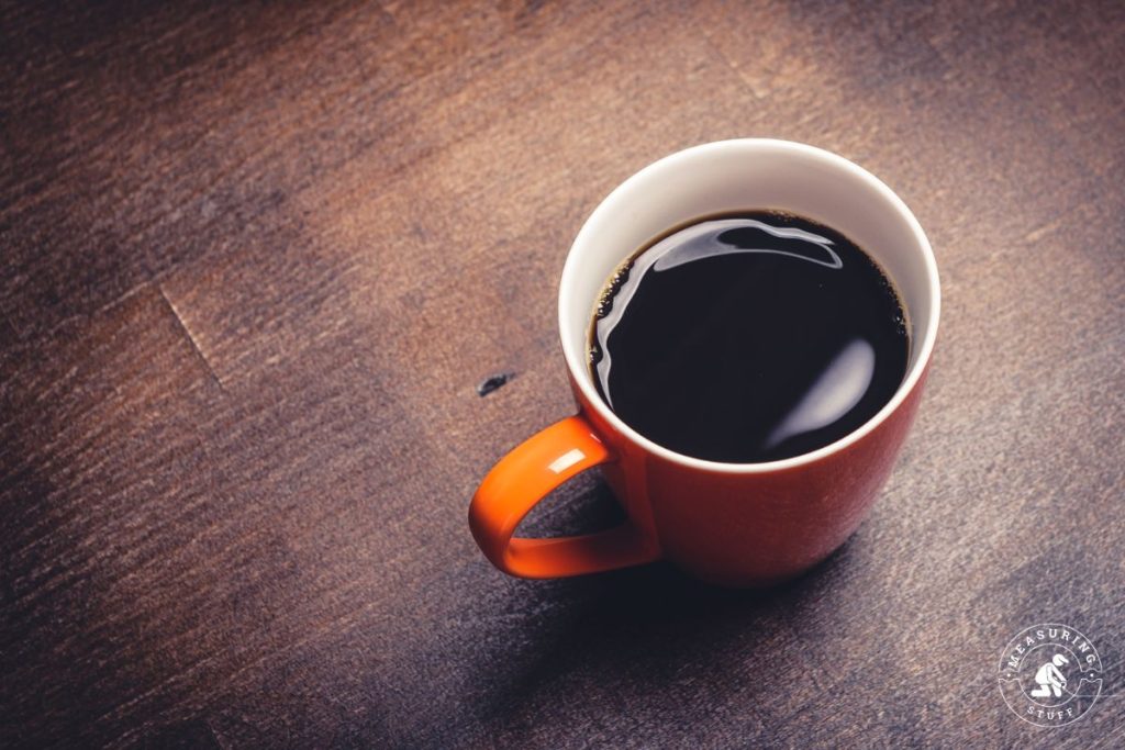 dark coffee in ceramic mug on a wood table