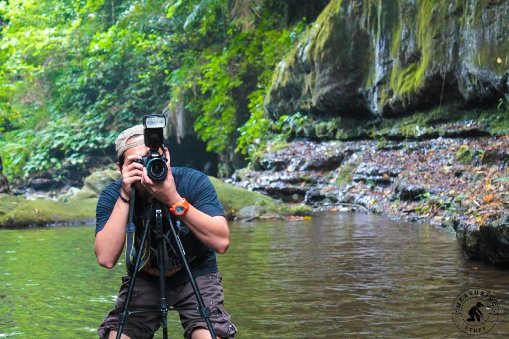 man taking a photo next to a river