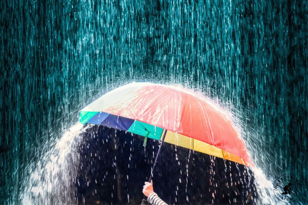 holding umbrella in heavy rain