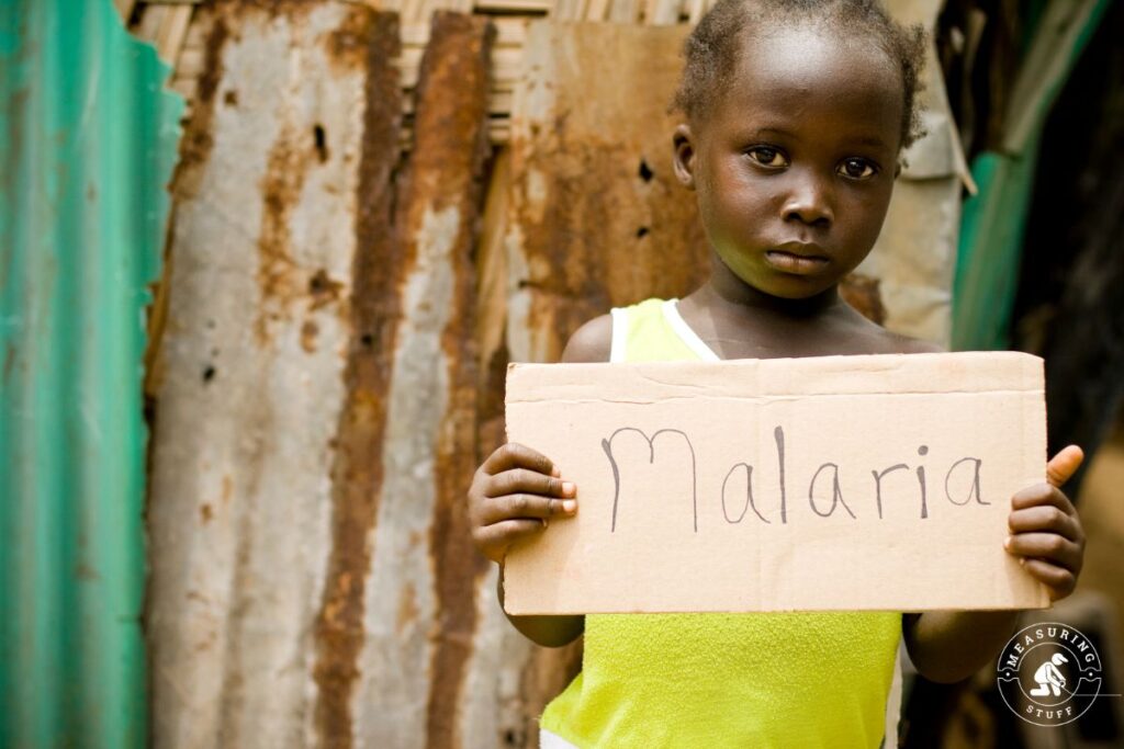 child holding a malaria sign