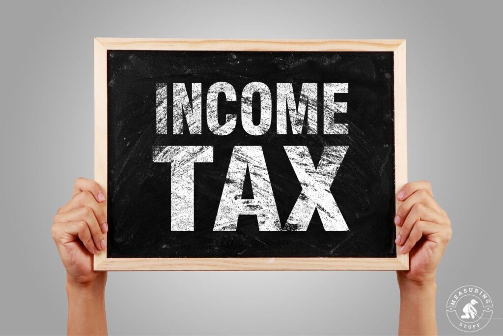 holding an income tax chalkboard sign