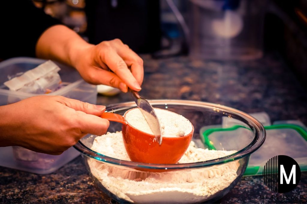 measuring a cup of flour with a knife
