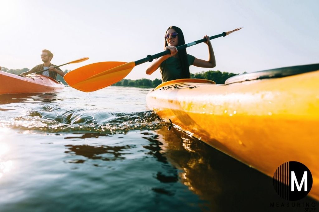 woman paddling a kayak on a lake