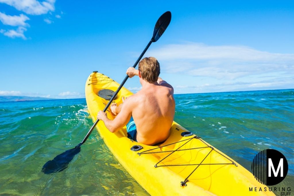 man paddling a kayak on a wave