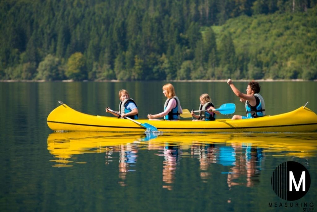 family sitting in a kayak on the lake