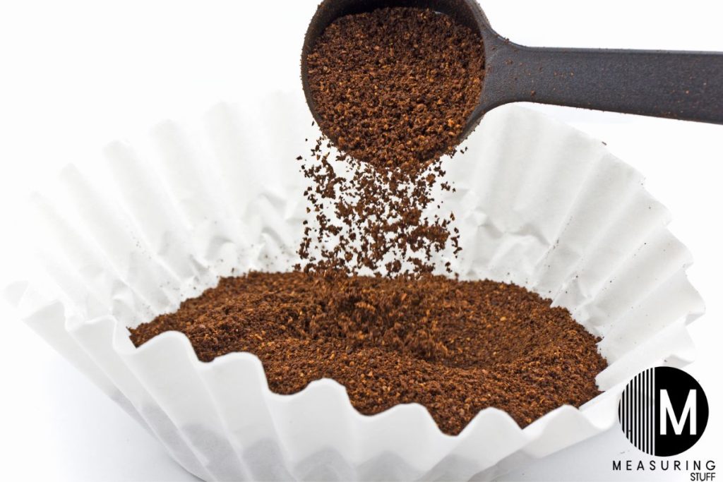 pouring coffee grounds into a filter