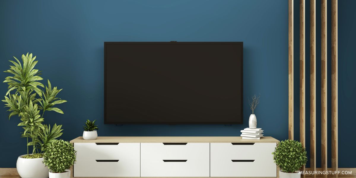 flat screen tv above a wooden cabinet