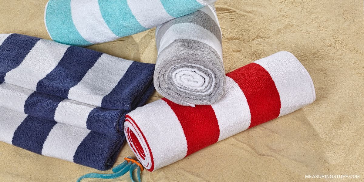 rolled up beach towels on sand