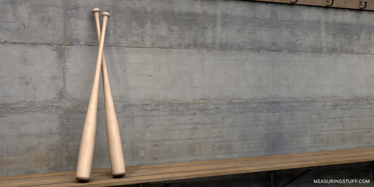 pair of baseball bats against a wall