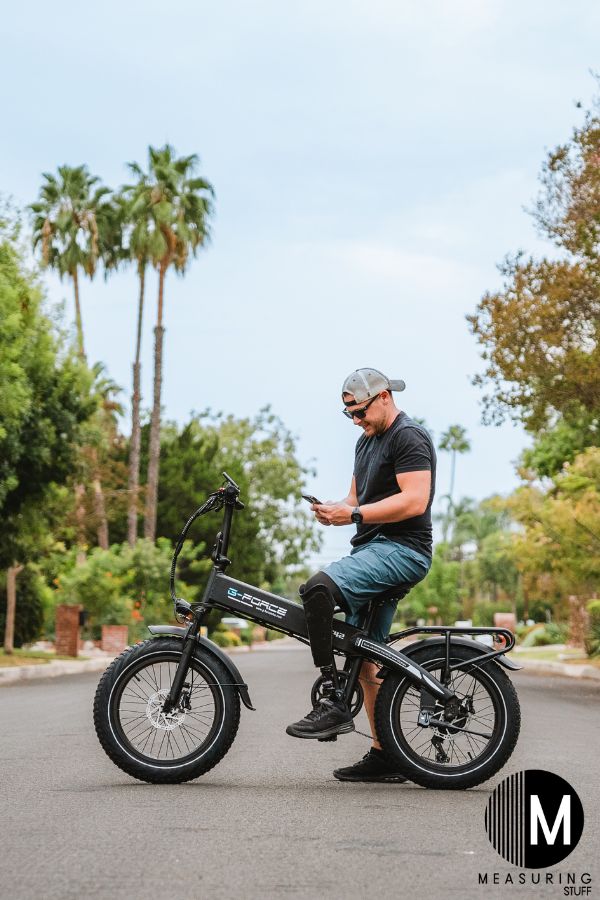 man sitting on an ebike using a cell phone