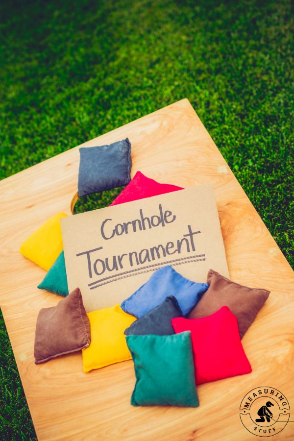 cornhole board with tournament sign and bags