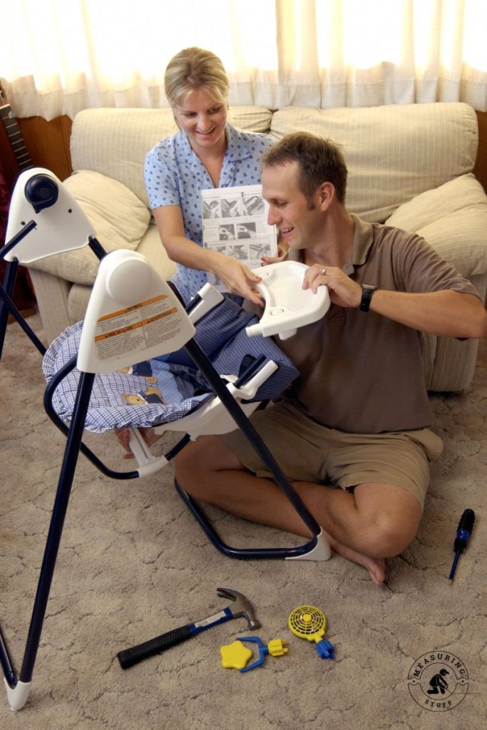 parents assembling a baby swing