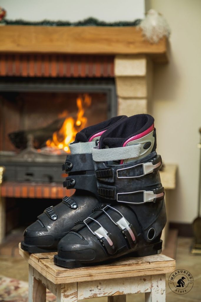 ski boots next to a fireplace