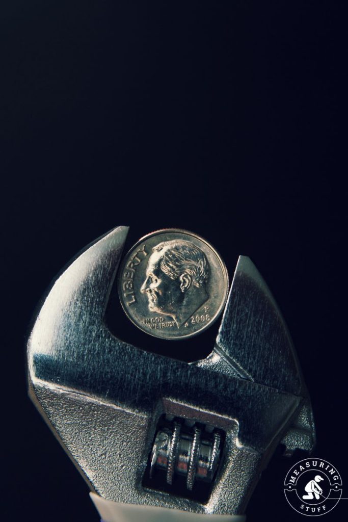 a wrench holding a dime