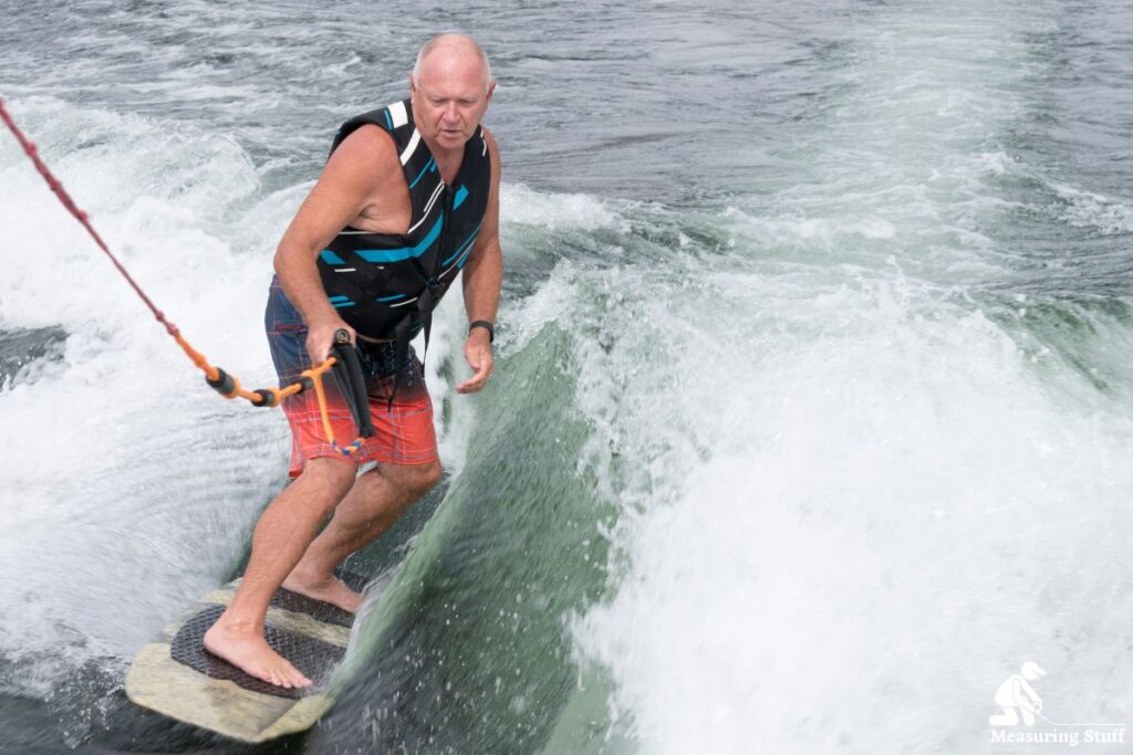 man holding onto a rope while wakesurfing