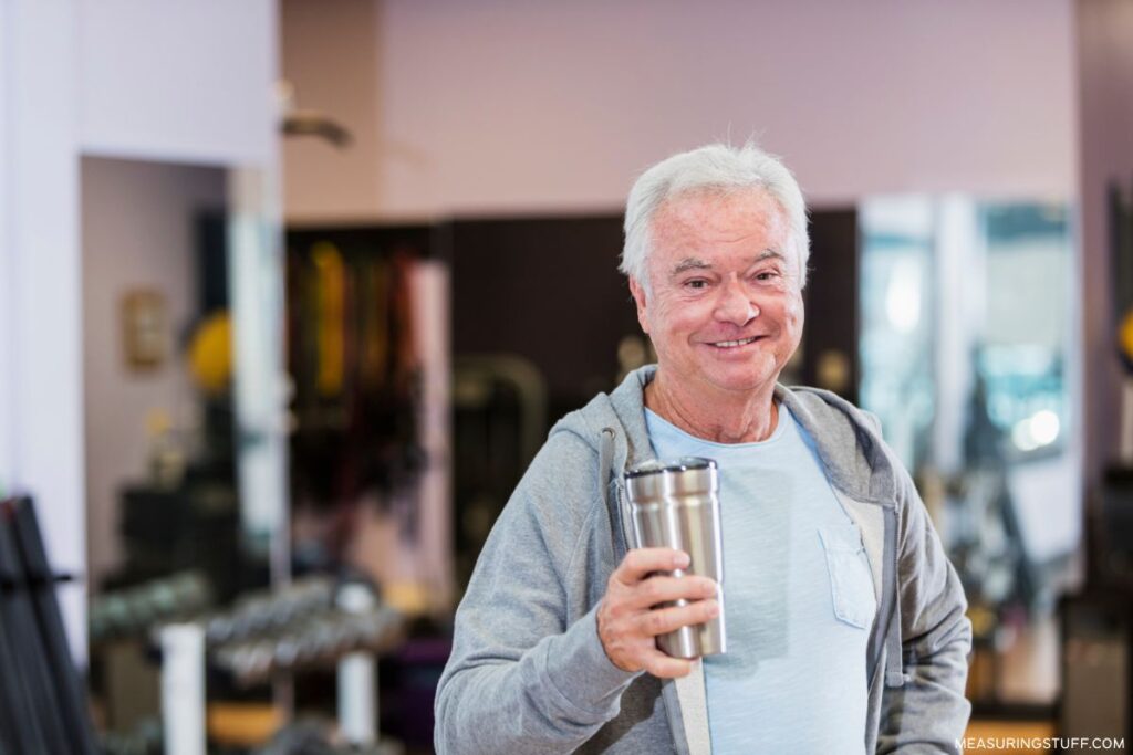 senior man holding a travel mug