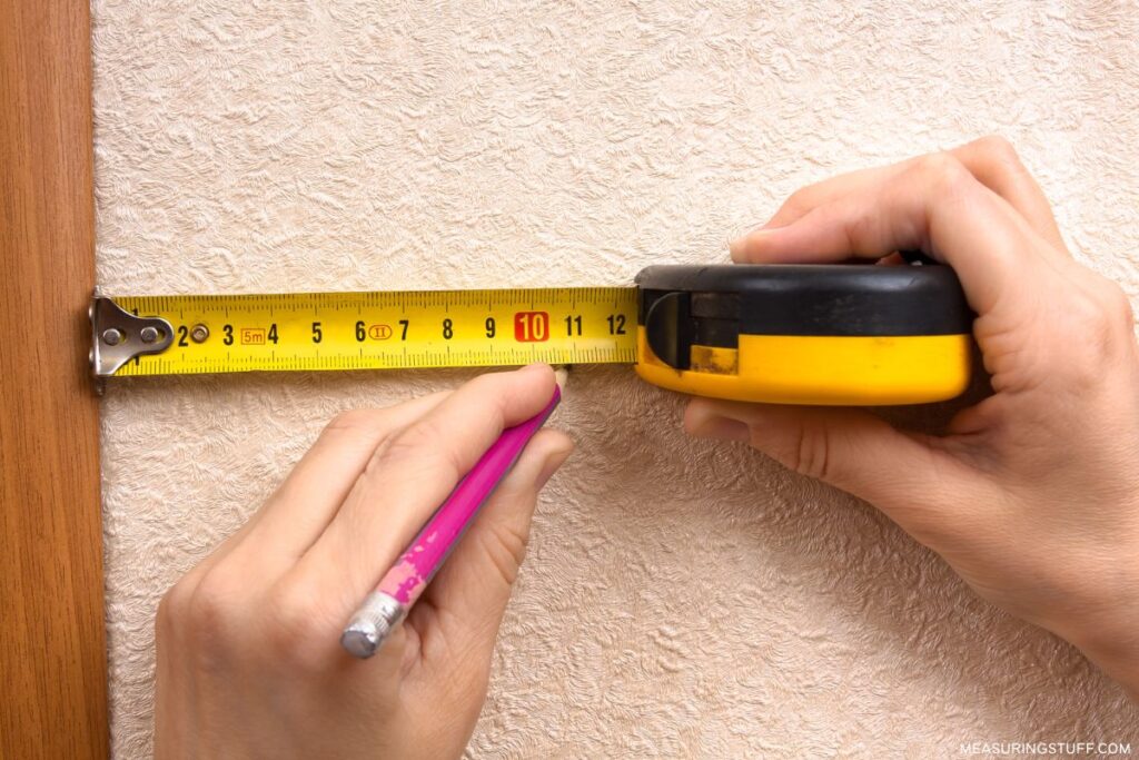 marking a line on wall with measuring tape