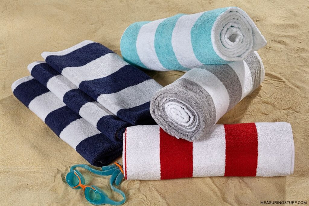 rolled up beach towels on sand