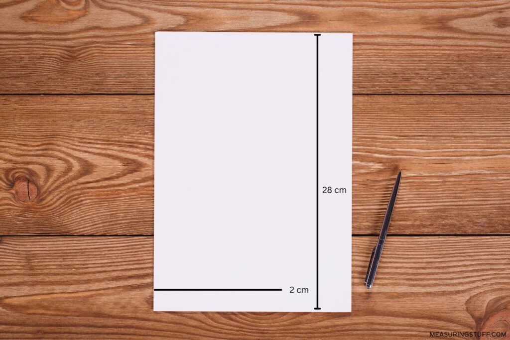 sheet of paper and pen on a desk with 2 and 28 cm markings
