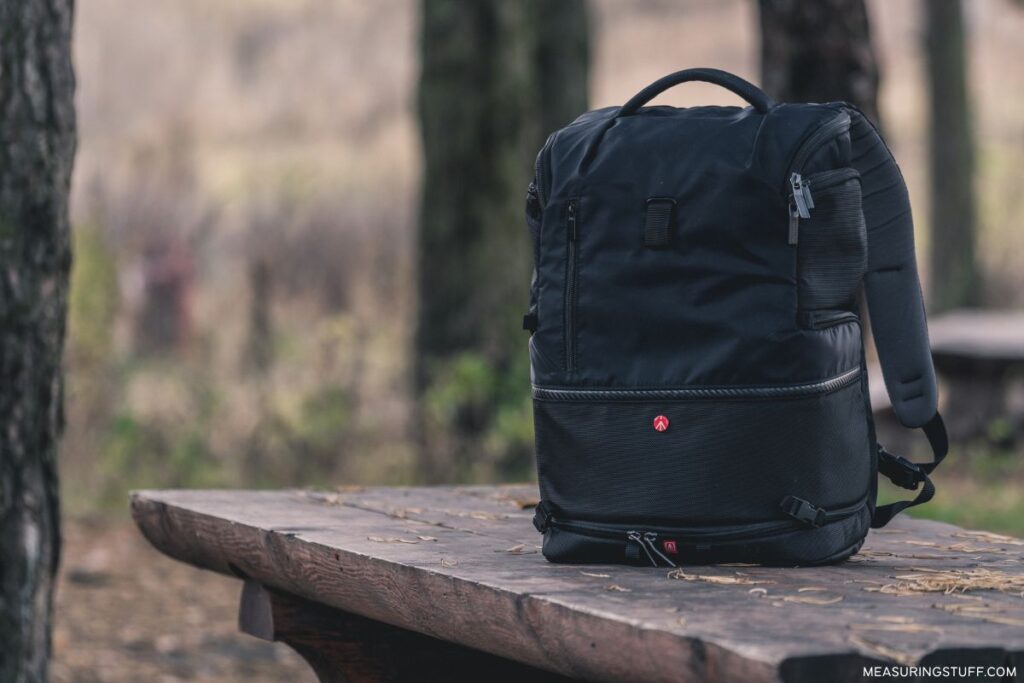 black backpack sitting on a wooden bench