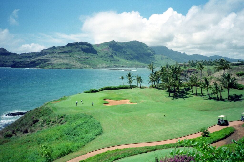overhead view of players on golf course with mountains in background