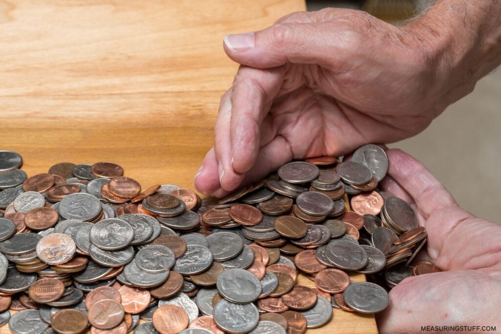 man sweeping mixed coins with hands