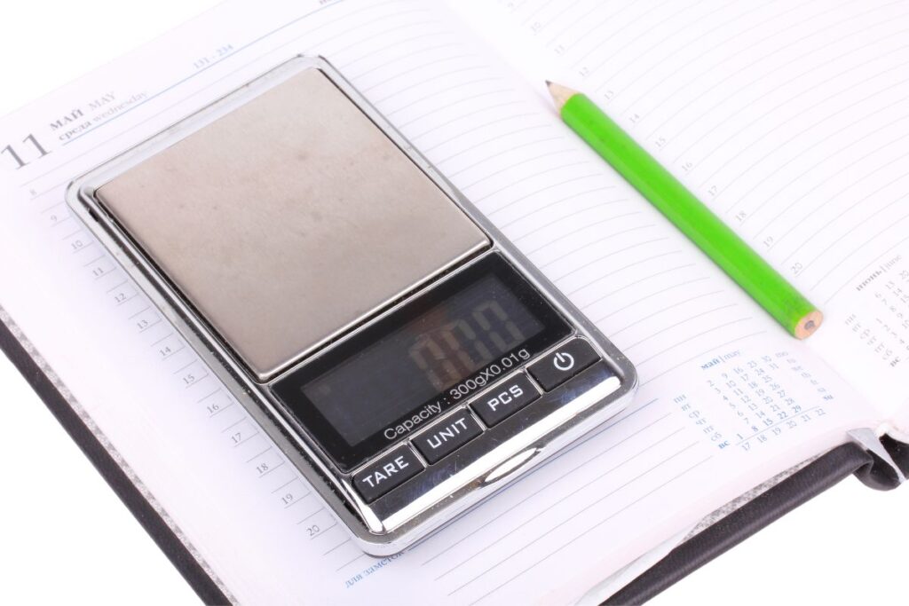 digital scale on an open book with a pencil